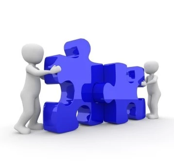 Dieses lizenzfreie pixabay-Bild von Peggy Marco zeigt zwei weiße Männchen, die zwei perfekt passende, große, blaue Puzzleteile zusammenfügen.